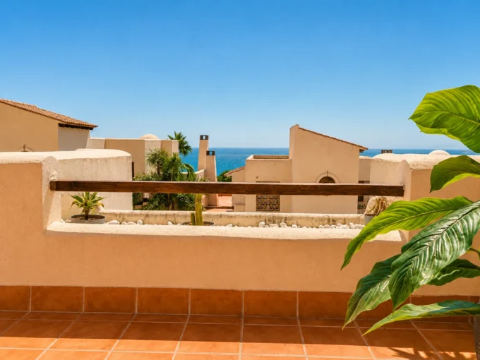 Terrasse carrelée avec vue sur la mer par-dessus les toits de maisons ocre