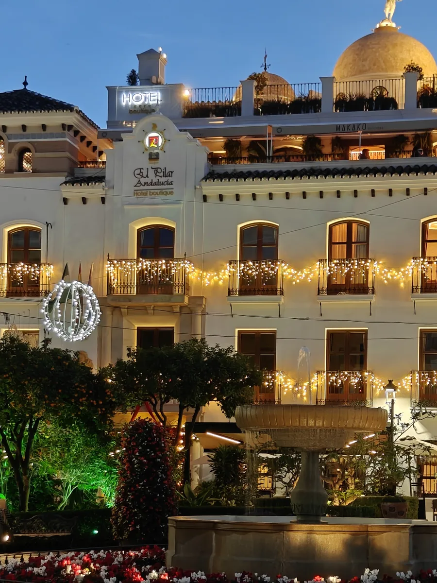 The Plaza El Pilar in Estepona illuminated in December, fountain and flower beds
